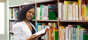 young african college student reading in library